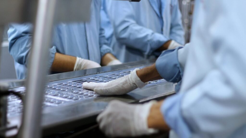 Workers in a pharmaceutical facility packaging tablets in Islamabad.