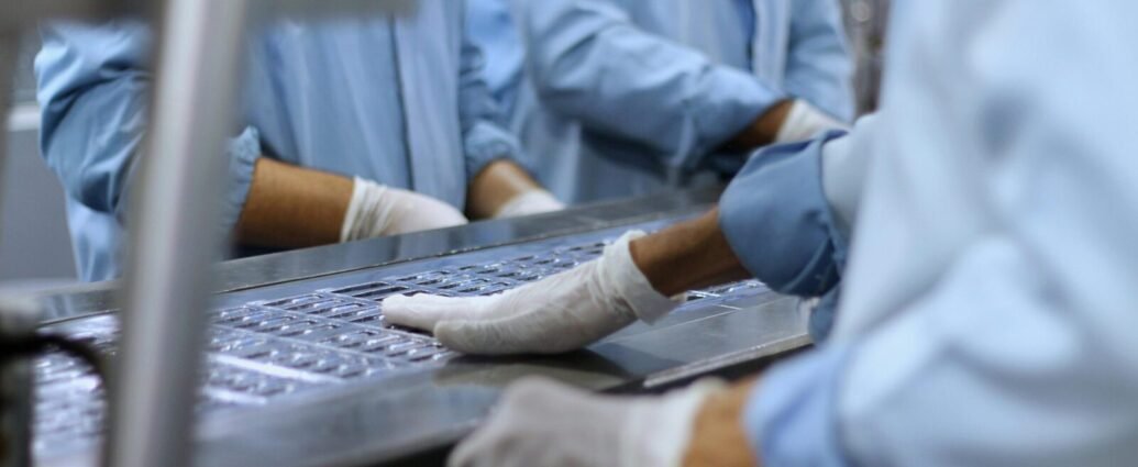 Workers in a pharmaceutical facility packaging tablets in Islamabad.